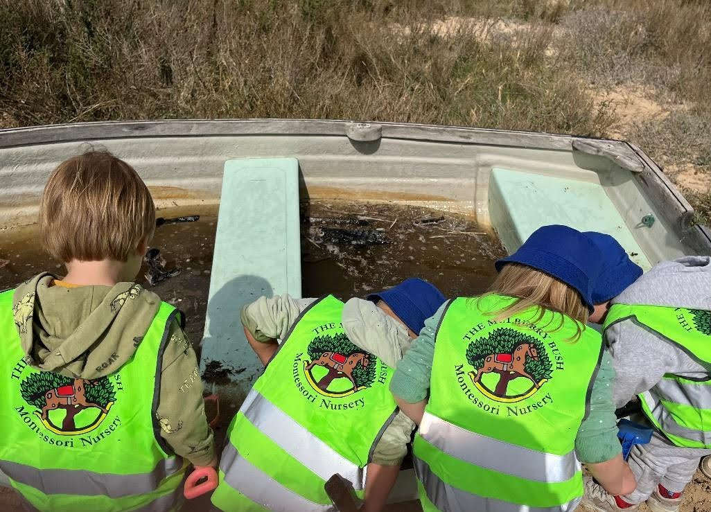 Children exploring in upturned boat